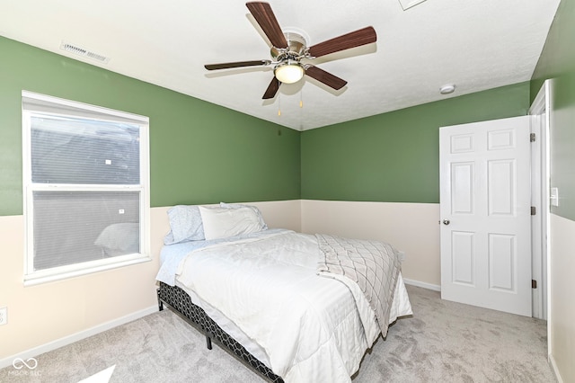 carpeted bedroom featuring visible vents, baseboards, and a ceiling fan