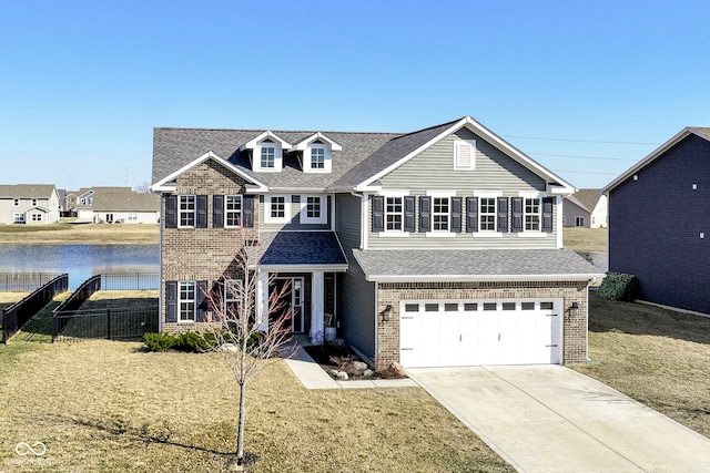 traditional-style home with a front yard, fence, an attached garage, concrete driveway, and a water view