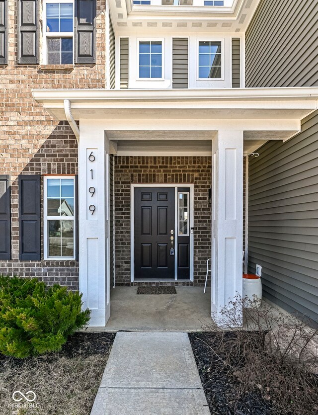 property entrance featuring brick siding