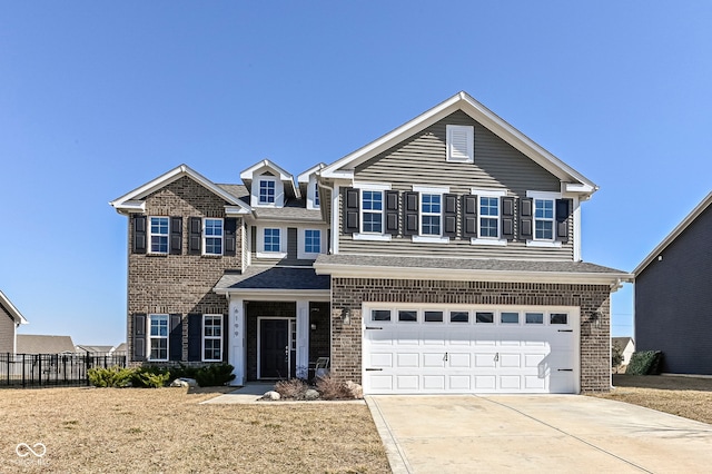 traditional home featuring brick siding, an attached garage, concrete driveway, and fence