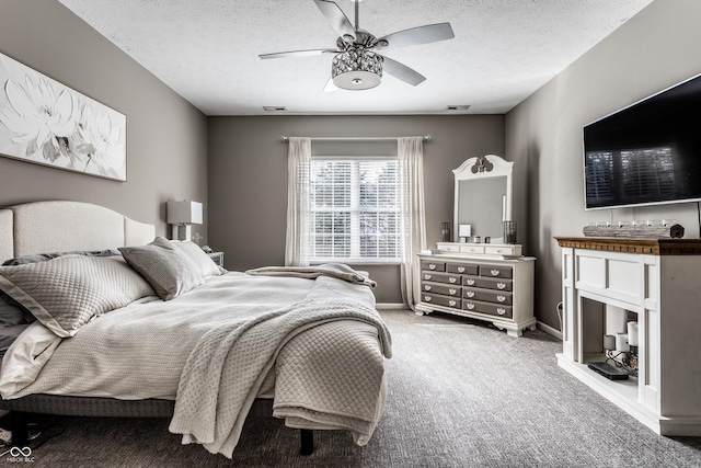 bedroom featuring visible vents, a textured ceiling, baseboards, light colored carpet, and ceiling fan