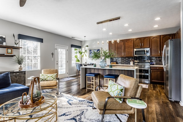 living area featuring recessed lighting, baseboards, a textured ceiling, and dark wood finished floors