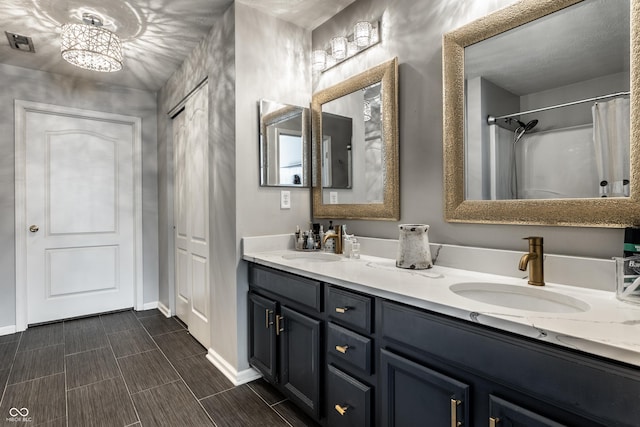 bathroom featuring double vanity, visible vents, baseboards, and a sink