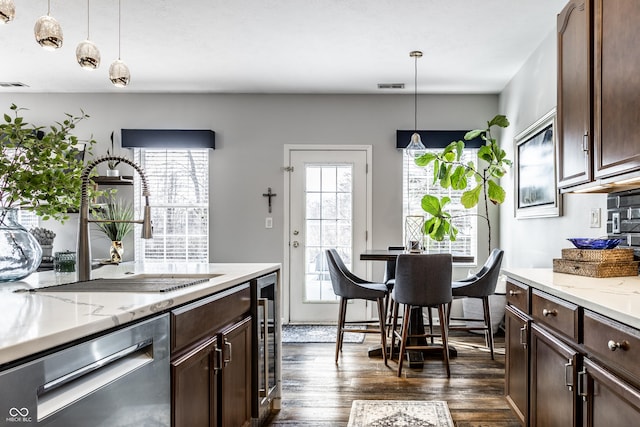 kitchen featuring visible vents, dark wood finished floors, a sink, dark brown cabinetry, and dishwasher