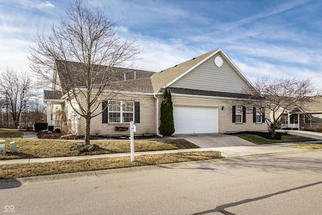 view of front of house with brick siding, driveway, an attached garage, and roof with shingles