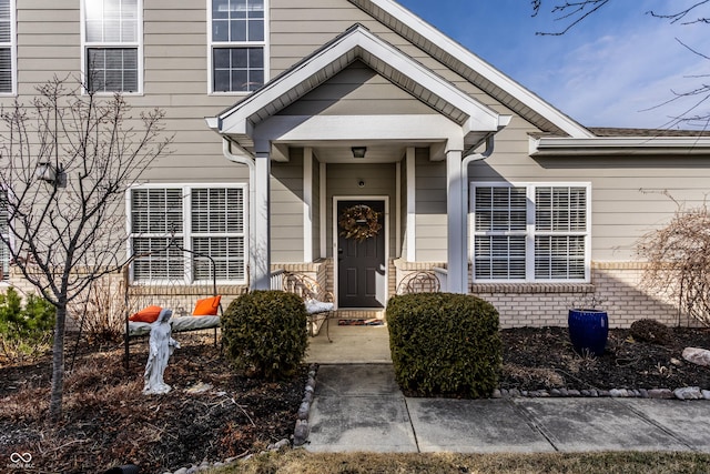 doorway to property featuring brick siding