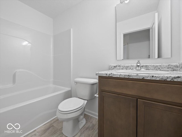 bathroom with baseboards, toilet, and vanity