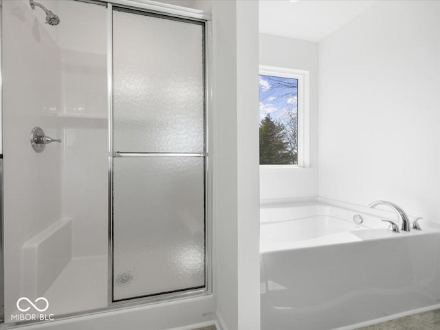 bathroom featuring a stall shower and a garden tub