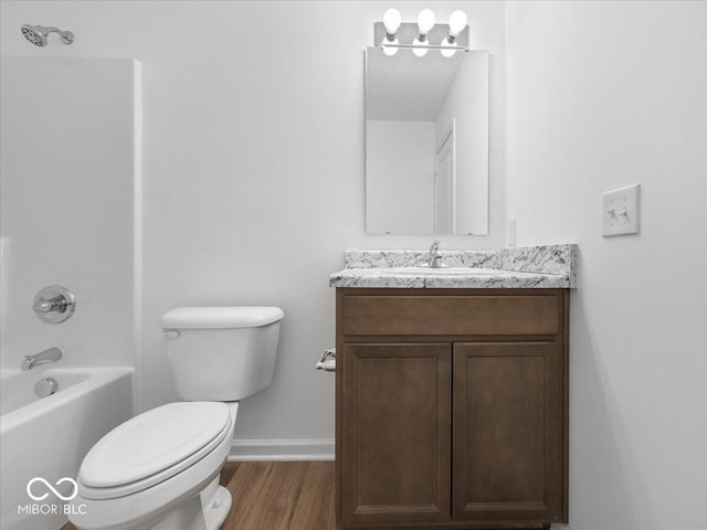 full bathroom with vanity, wood finished floors, baseboards, tub / shower combination, and toilet