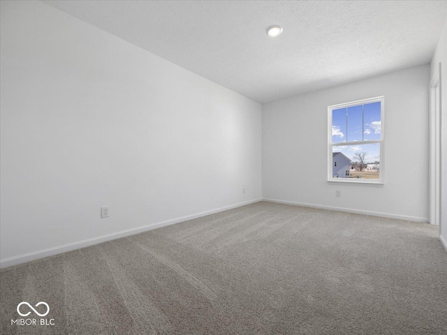 empty room with baseboards, carpet floors, and a textured ceiling