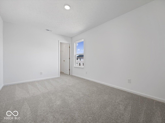 empty room featuring visible vents, a textured ceiling, baseboards, and carpet floors