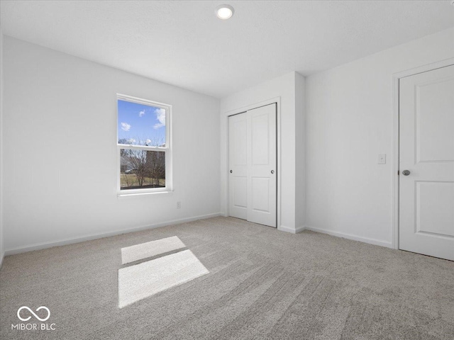 unfurnished bedroom with a closet, baseboards, and carpet