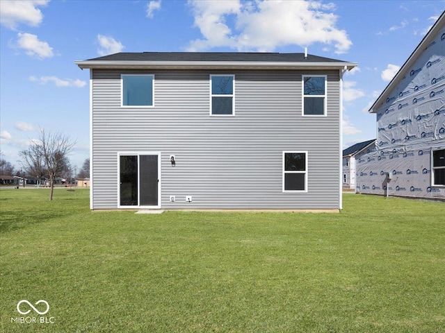 rear view of house featuring a lawn