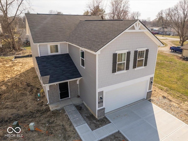 view of front of property with driveway, covered porch, a front yard, a shingled roof, and a garage