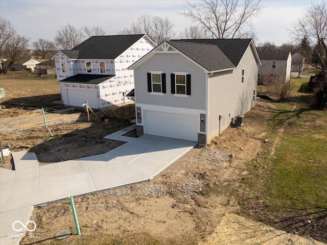 view of front of house featuring central AC, concrete driveway, and an attached garage