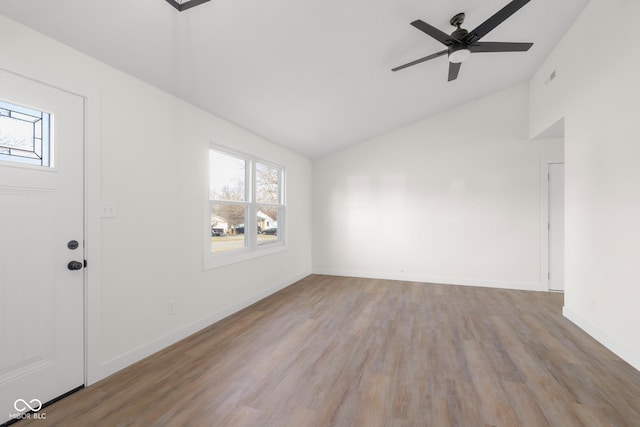 foyer entrance featuring plenty of natural light, wood finished floors, baseboards, and vaulted ceiling