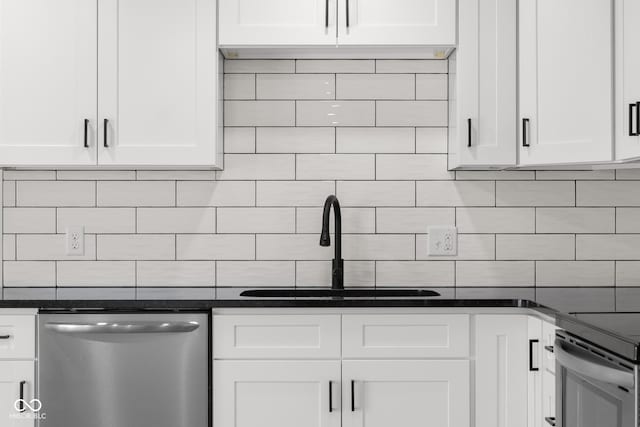 kitchen featuring tasteful backsplash, white cabinets, stainless steel appliances, and a sink