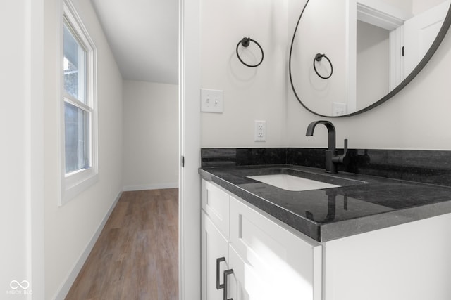 bathroom with baseboards, wood finished floors, and vanity