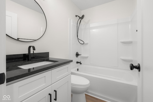 bathroom featuring toilet, washtub / shower combination, vanity, and wood finished floors