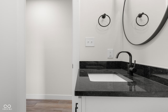 bathroom featuring vanity, wood finished floors, and baseboards