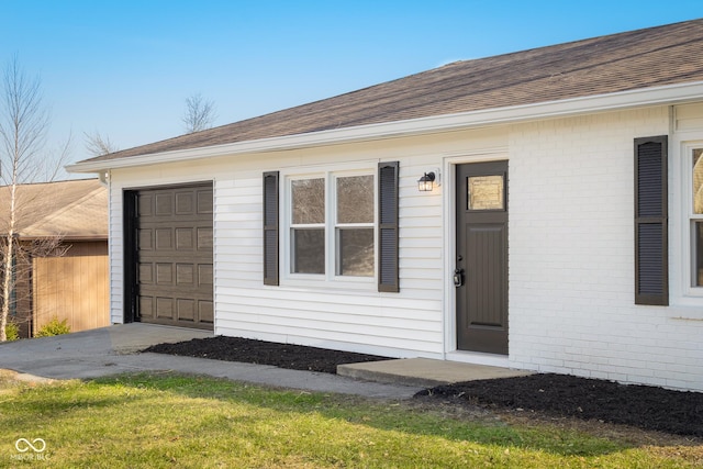 property entrance featuring brick siding, fence, a garage, and roof with shingles