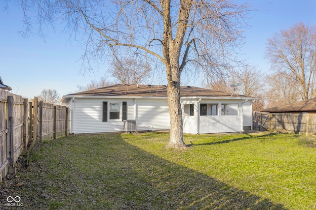 back of property featuring a yard, central air condition unit, and a fenced backyard