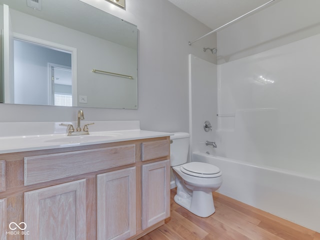 full bathroom with toilet,  shower combination, wood finished floors, and vanity