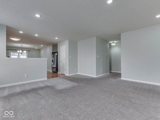 unfurnished living room featuring recessed lighting, baseboards, and carpet