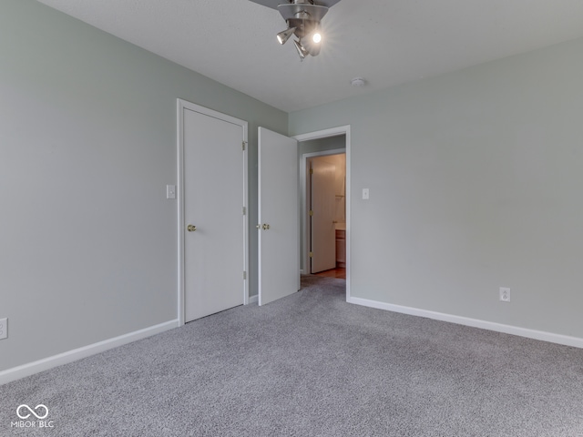 unfurnished bedroom with a ceiling fan, baseboards, and carpet floors