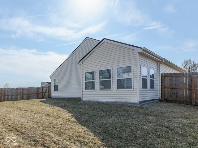 view of side of home featuring a lawn and a fenced backyard