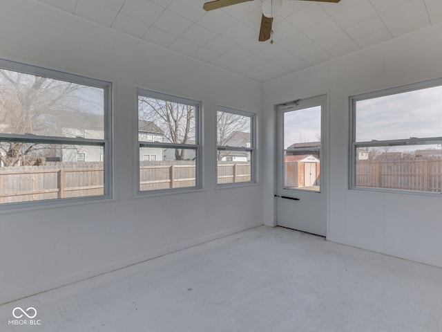 unfurnished sunroom with ceiling fan