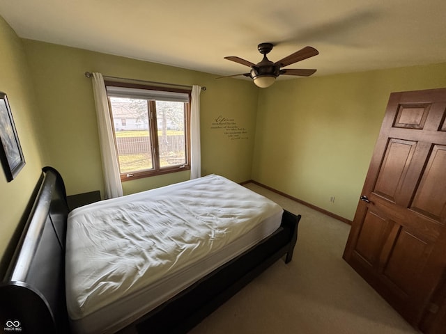 carpeted bedroom featuring baseboards and a ceiling fan