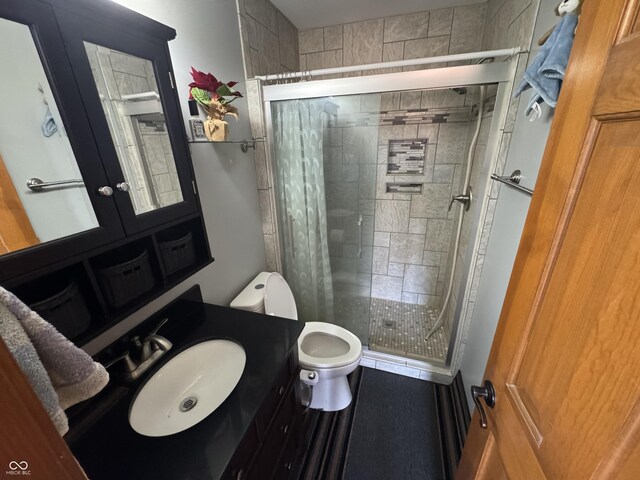 full bathroom featuring a shower stall, toilet, and vanity