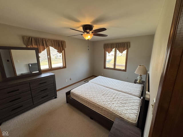 carpeted bedroom featuring a ceiling fan and baseboards