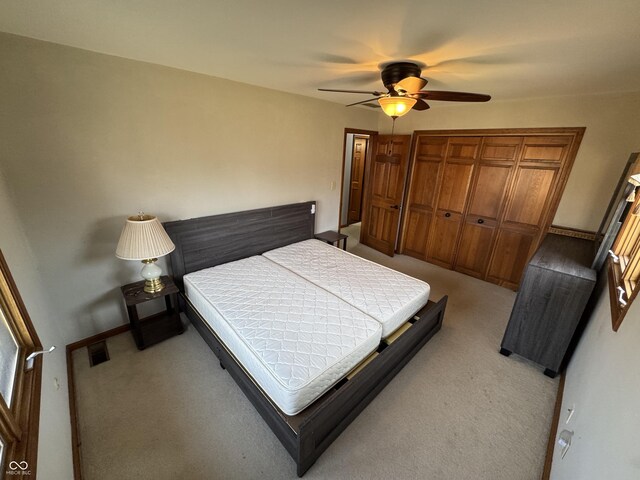 bedroom with visible vents, light colored carpet, and ceiling fan