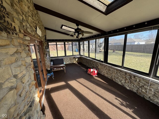 unfurnished sunroom with lofted ceiling with skylight