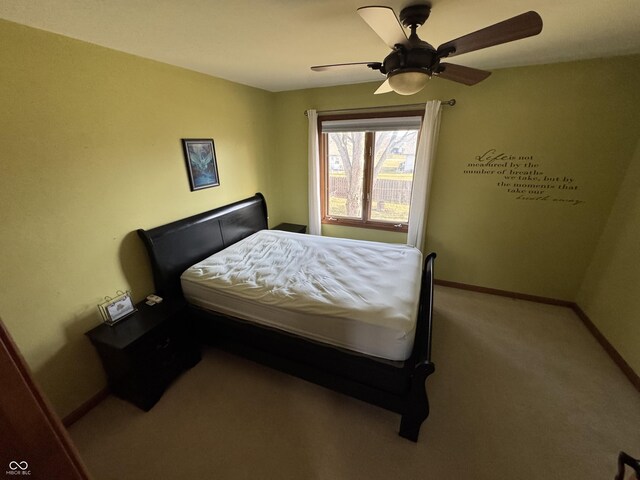 carpeted bedroom featuring baseboards and ceiling fan