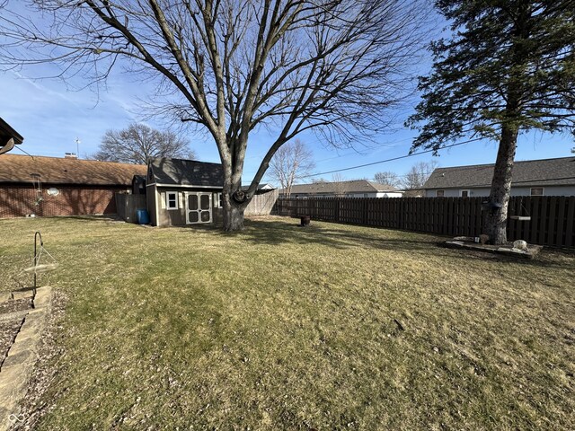 view of yard with an outdoor structure and a fenced backyard