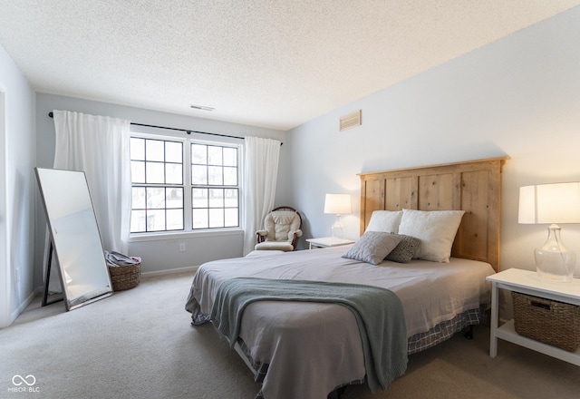 bedroom with visible vents, carpet flooring, a textured ceiling, and baseboards