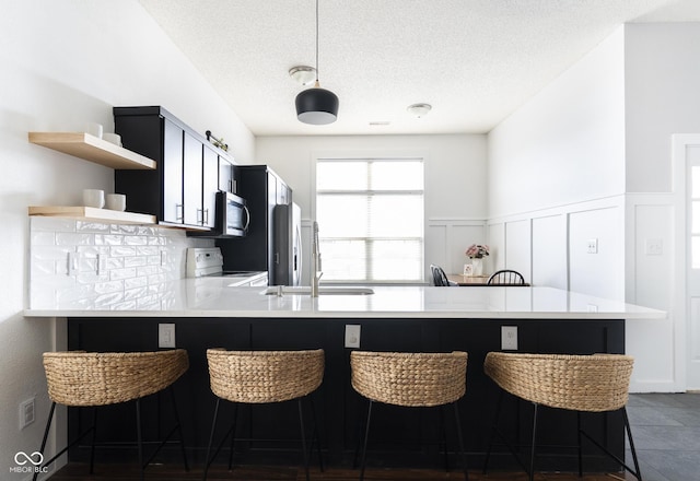 kitchen featuring open shelves, stainless steel microwave, white electric range, a peninsula, and light countertops