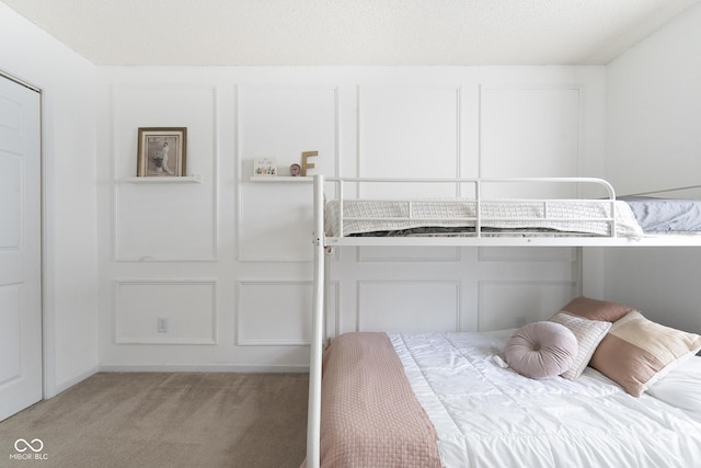 bedroom with a decorative wall and light carpet