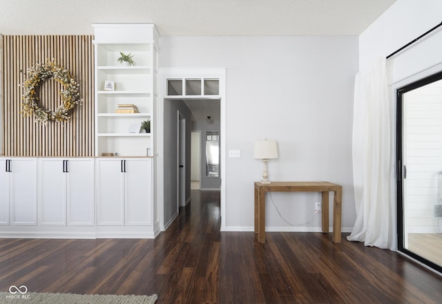 interior space featuring dark wood-type flooring and baseboards