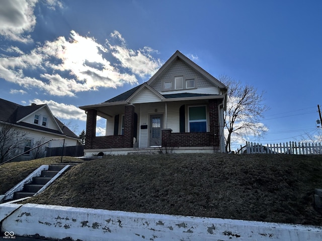 bungalow-style house with brick siding and covered porch