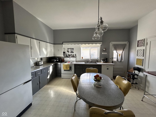 kitchen featuring a sink, white cabinetry, white electric stove, freestanding refrigerator, and light floors