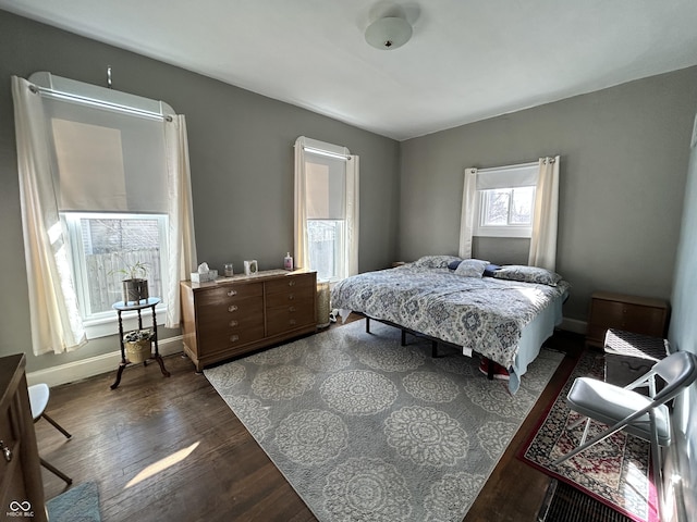 bedroom with baseboards and dark wood-style flooring