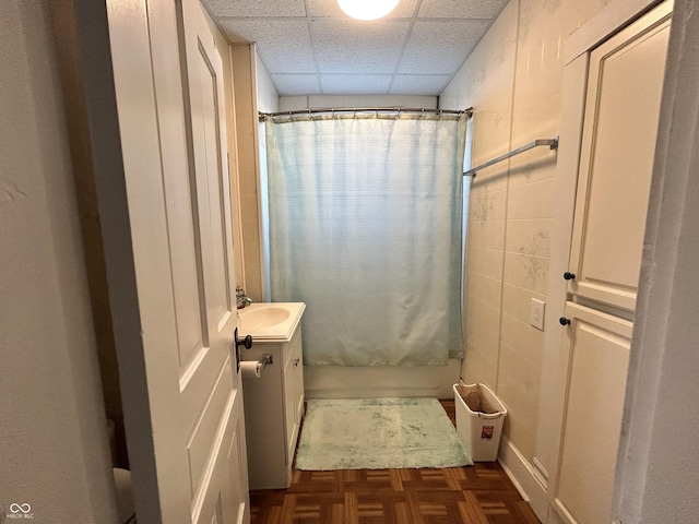 full bath with a drop ceiling, vanity, and shower / bath combo with shower curtain