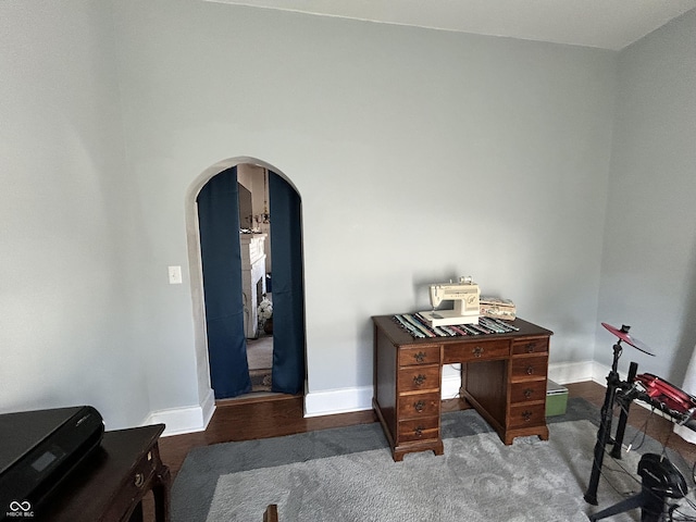 office featuring baseboards and arched walkways