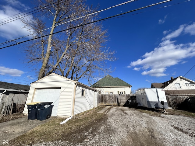 exterior space featuring a detached garage, an outdoor structure, and fence