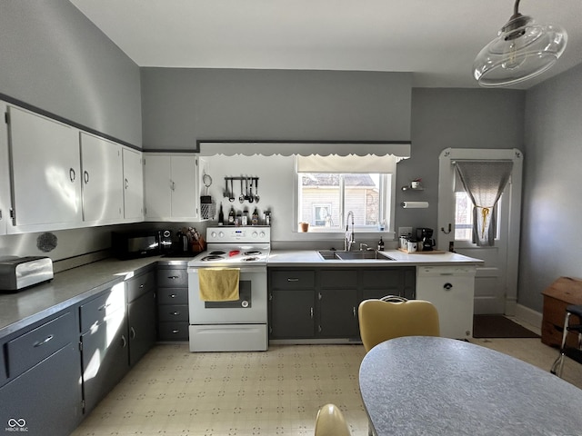 kitchen with light floors, white appliances, white cabinetry, and a sink