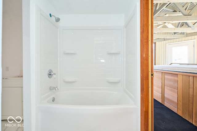 bathroom with vanity, shower / bathtub combination, and wood walls